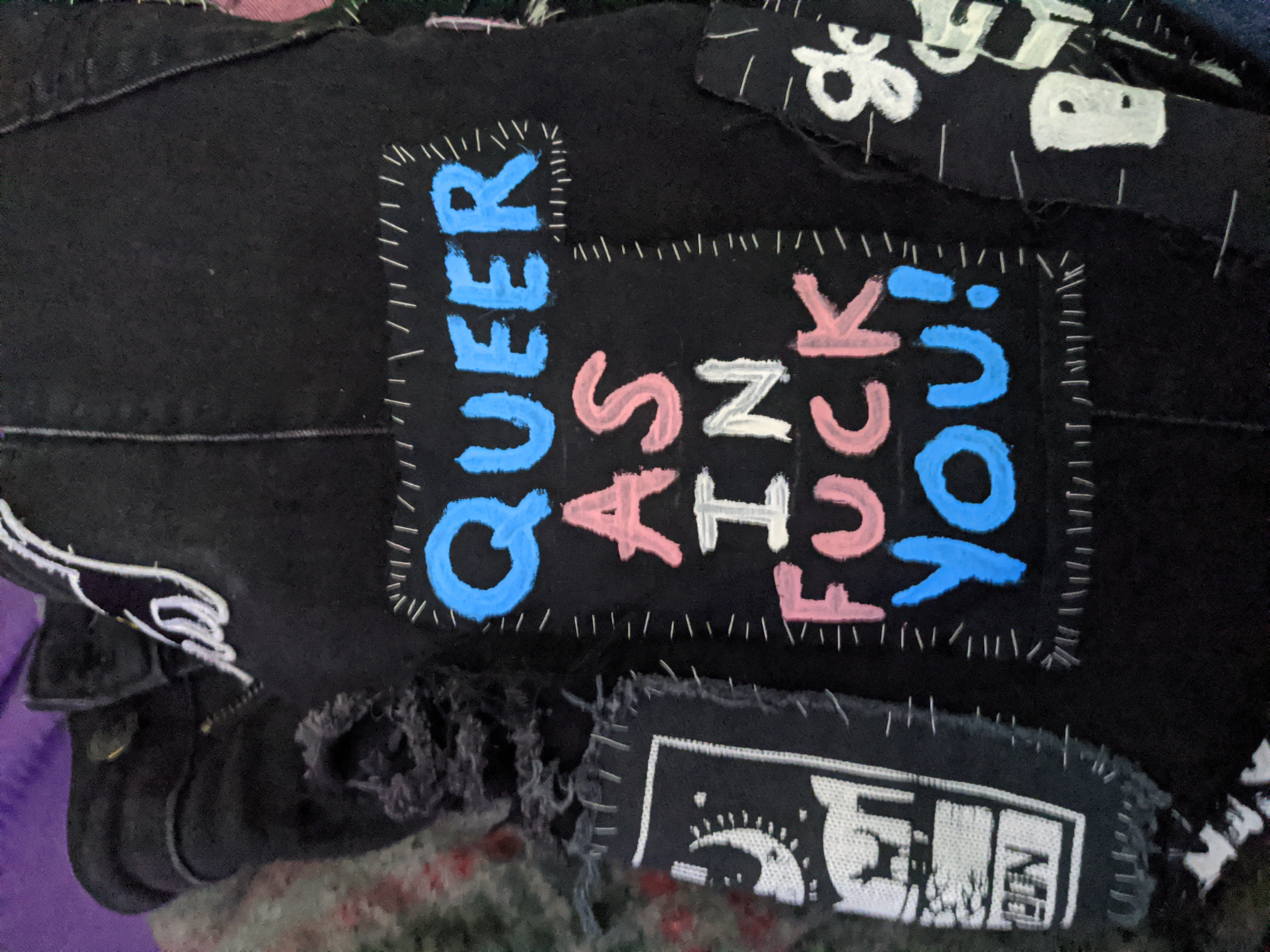 a patch that says queer as in fuck you! in the trans colors sewn onto my pants